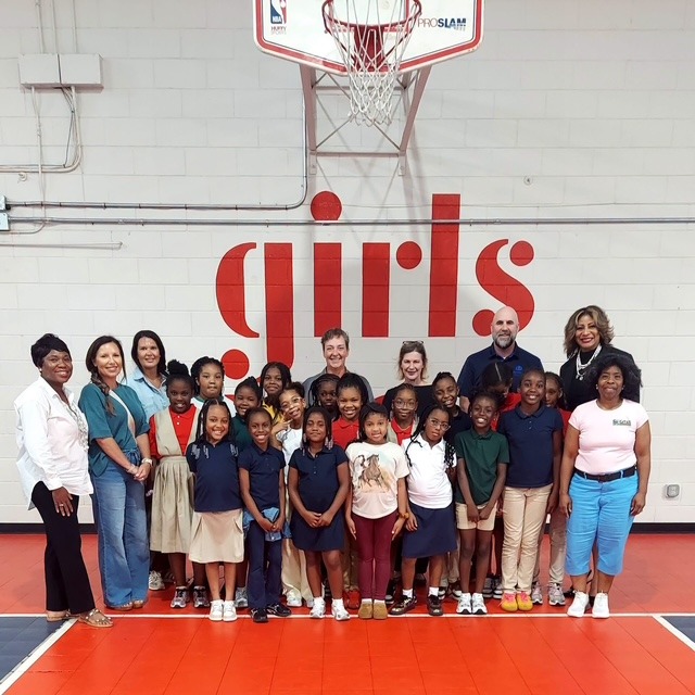 Girls Inc. participants and staff in a gym