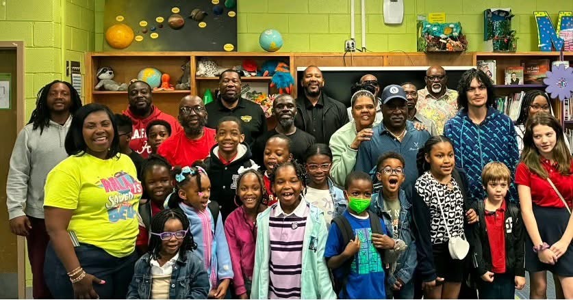 Families, fathers, and children gathered in a classroom